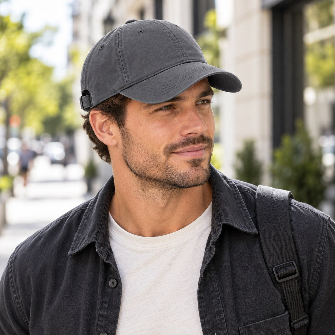 Man wearing a grey cap and dark jacket on a city street